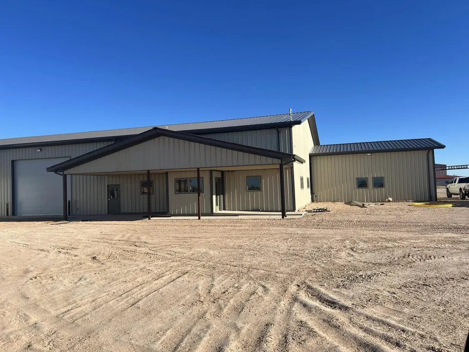 Completed steel building with tan siding and attached garage
