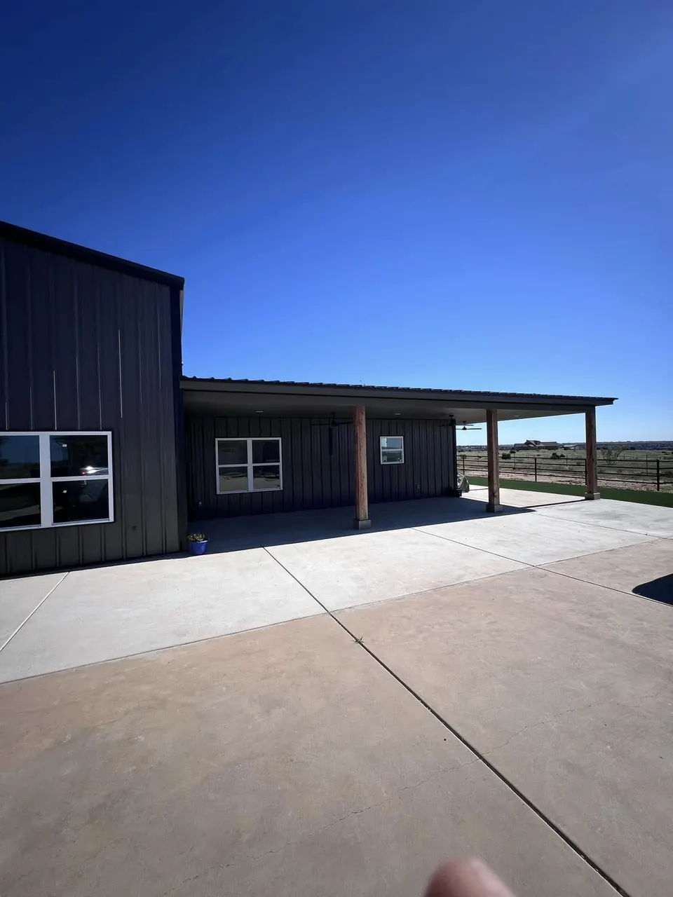Gray barndominium with wood post porch overhang