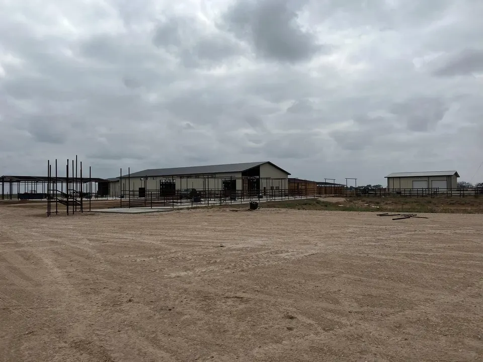 Steel columns rising from a poured concrete slab on a Homerun Fabrication build site
