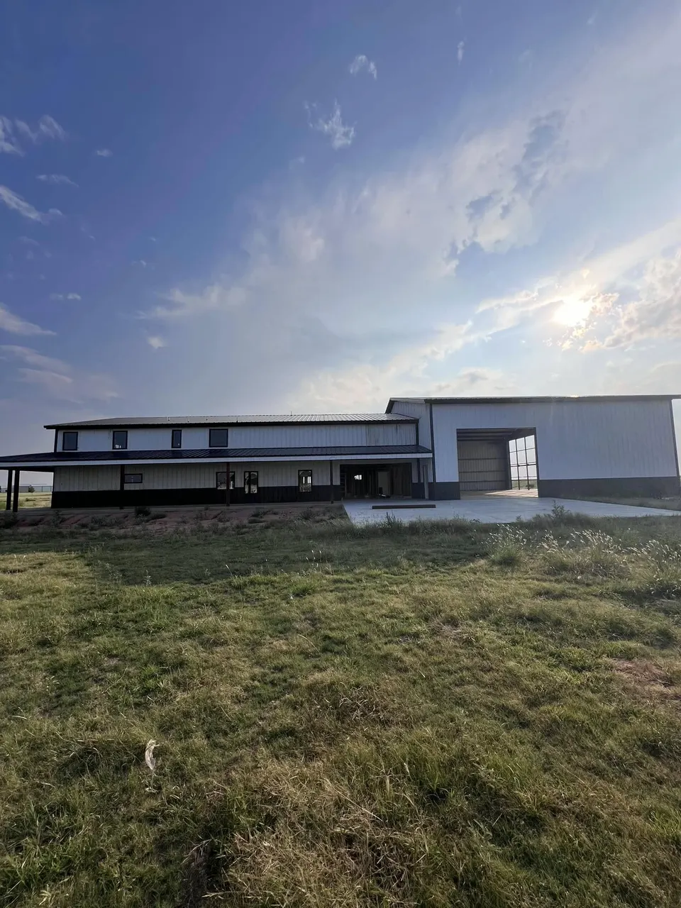 Two-story barndominium built by Homerun Fabrication at dusk in the Texas Panhandle